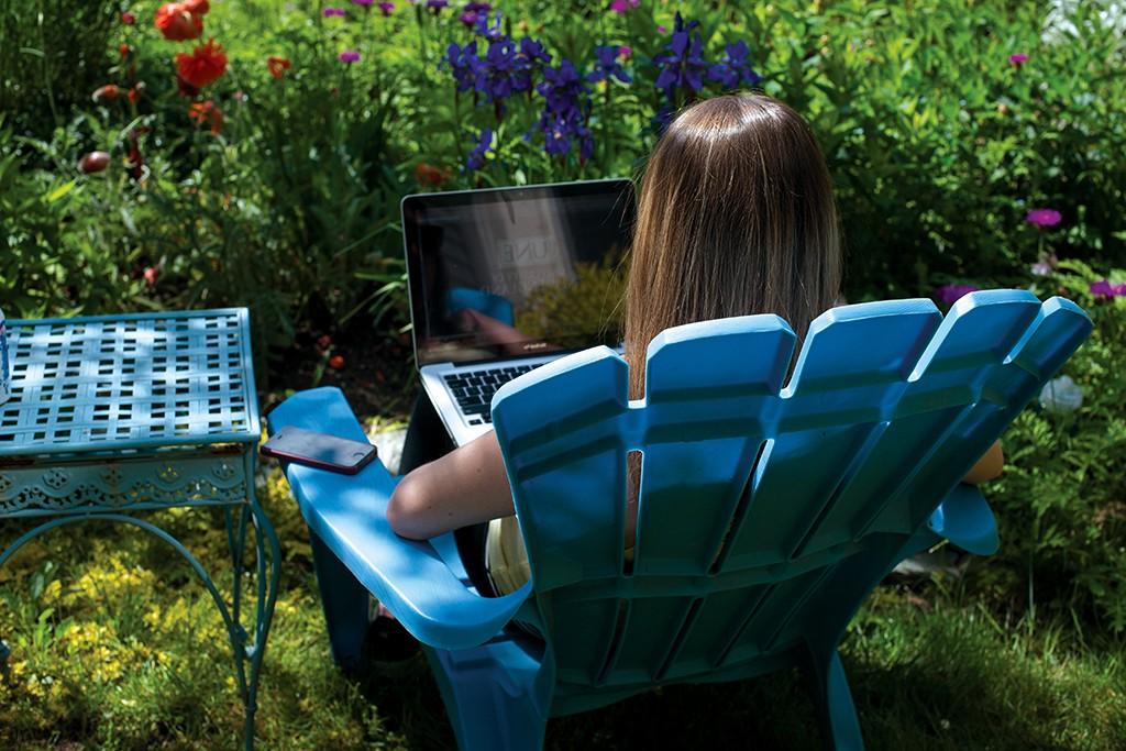 一位英国东北大学的学生坐在外面用笔记本电脑打字